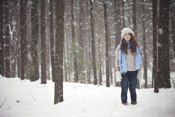 Girl standing in snowy forest