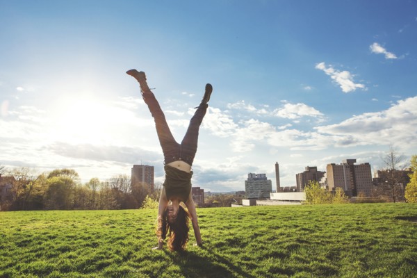 Caucasian woman doing handstand in urban park