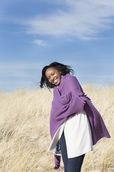 Woman wrapped in shawl on beach