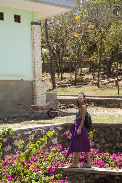 Woman walking by rock wall in garden