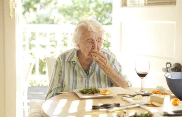 Older Caucasian woman eating lunch at table