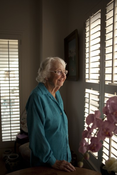 Smiling older Caucasian woman looking out window