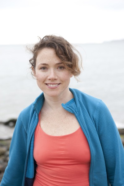 Caucasian woman smiling on rocky beach