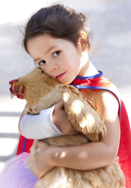 Mixed race girl hugging chicken