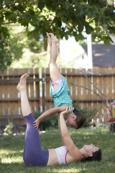 Mother and daughter practicing yoga in backyard