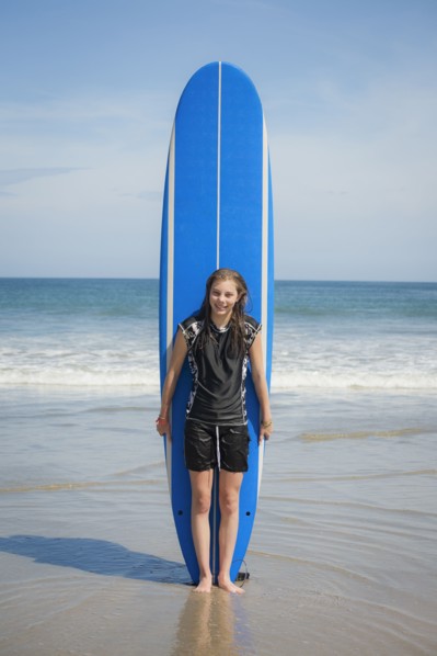 Caucasian girl holding paddleboard on beach