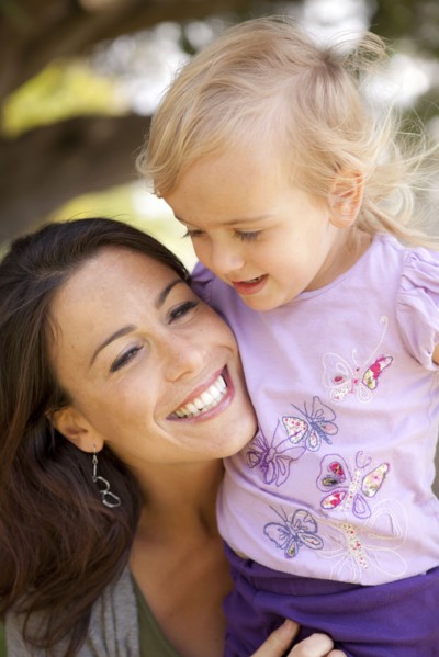 Caucasian mother and daughter smiling outdoors