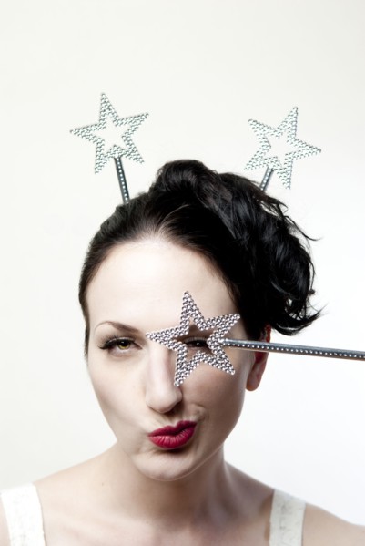 Glamorous winking woman holding star over eye