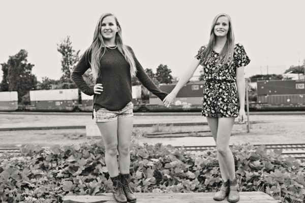 Teenage girls holding hands in train yard