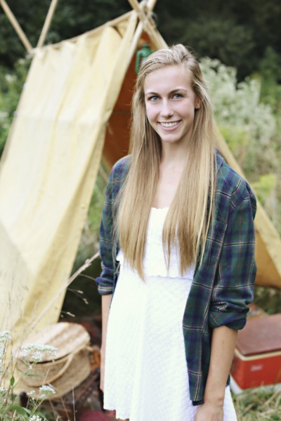 Smiling woman standing at camping tent