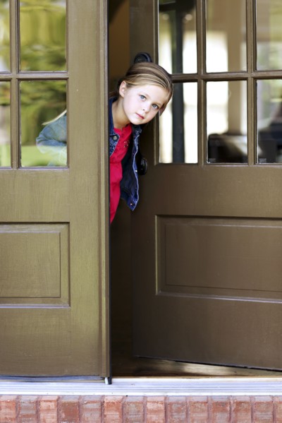 Curious girl standing in doorway