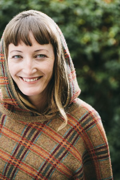 Mixed race woman wearing hood and shawl in backyard