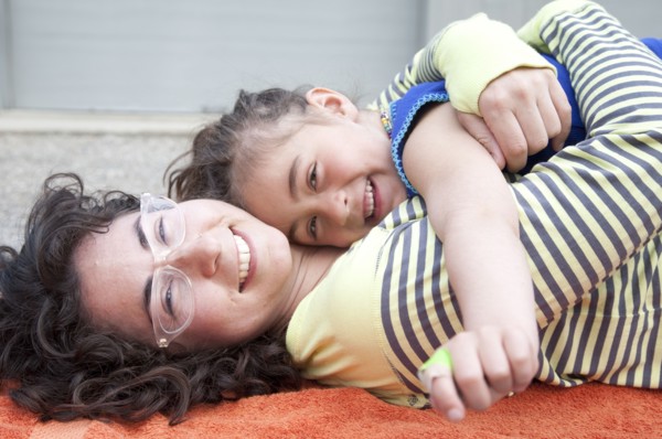 Caucasian mother and daughter hugging on carpet