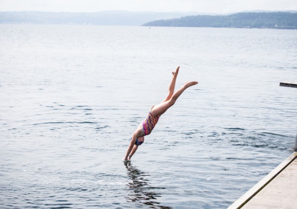 Caucasian girl diving into lake