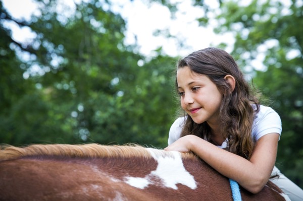 Close up of teenage girl riding horse