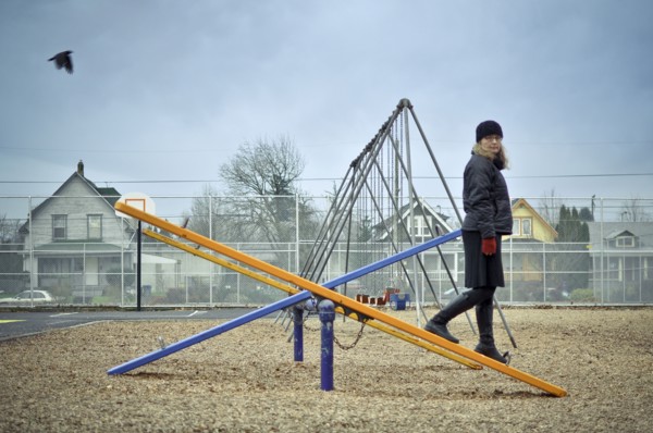 Caucasian woman walking on playground seesaw
