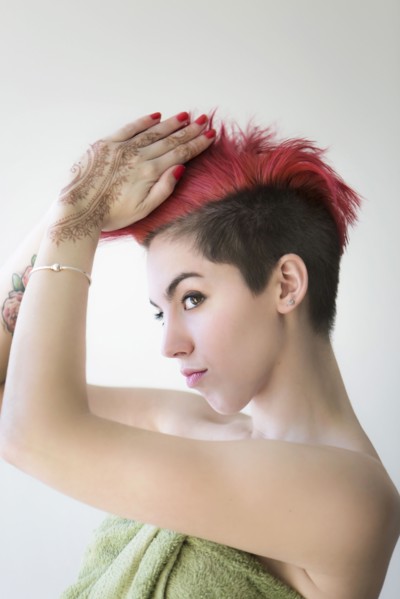 Caucasian woman styling dyed hair
