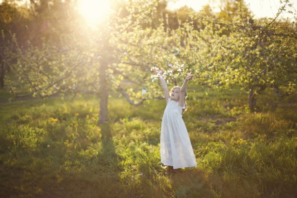 Caucasian girl tossing flower petals outdoors