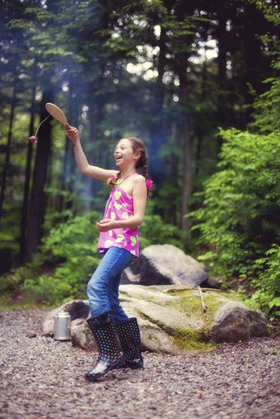 Caucasian girl playing with toy in forest
