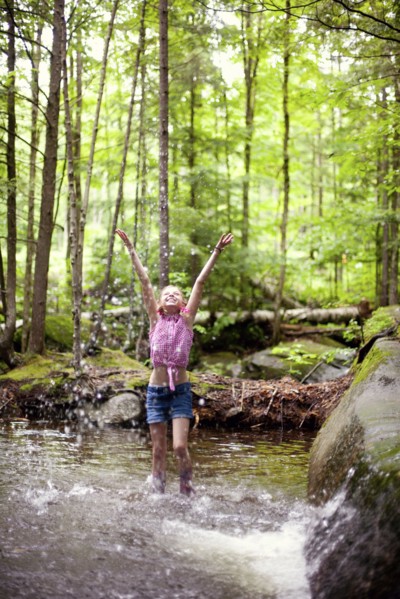 Caucasian girl splashing in river