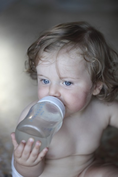 Caucasian baby girl drinking bottle