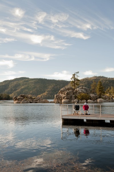 Couple sitting on wooden deck in remote lake