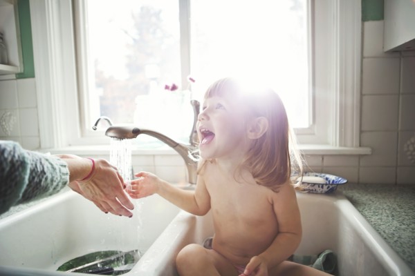 Girl bathing in kitchen sink