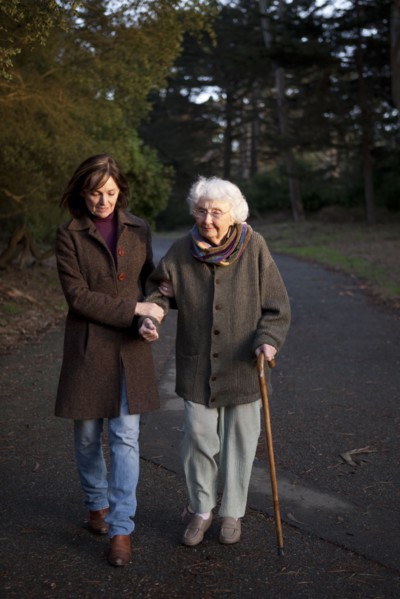 Woman walking with mother on paved path
