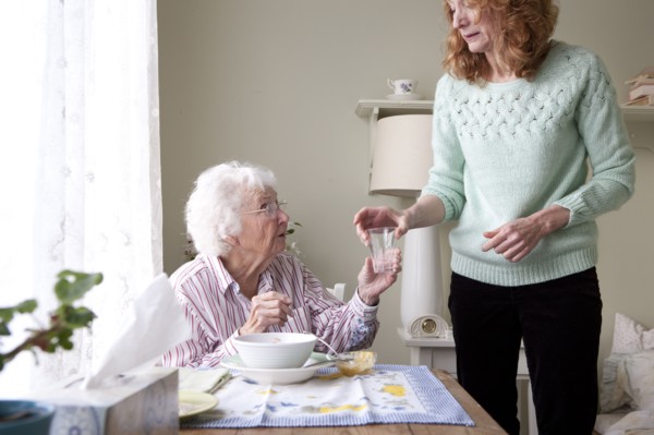 Woman giving mother glass of water