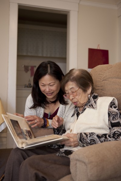 Asian mother and daughter looking at photo album