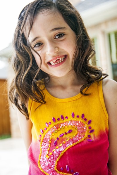 Smiling girl displaying missing teeth
