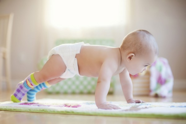 Mixed race baby girl playing on floor
