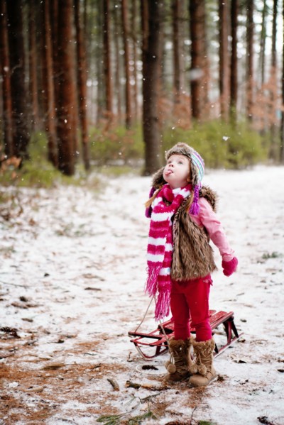 Caucasian girl catching snow on tongue