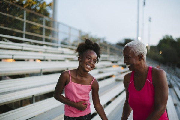 Grandmother and granddaughter standing on bleachers