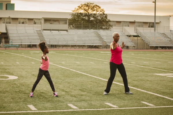 Grandmother and granddaughter exercising on football field