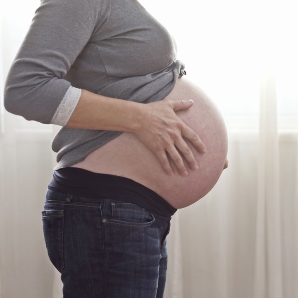 Pregnant Caucasian woman caressing stomach