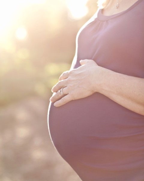 Pregnant Caucasian woman caressing stomach