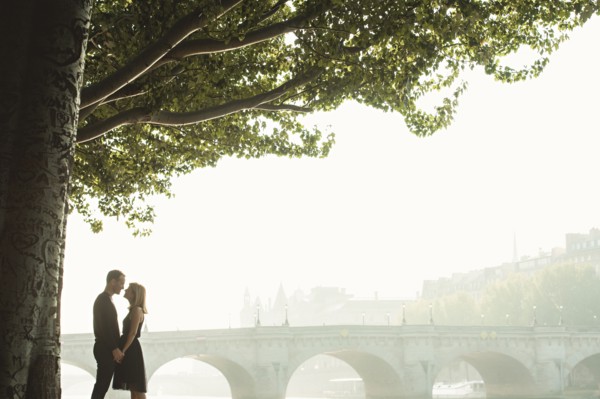 Caucasian couple kissing near bridge