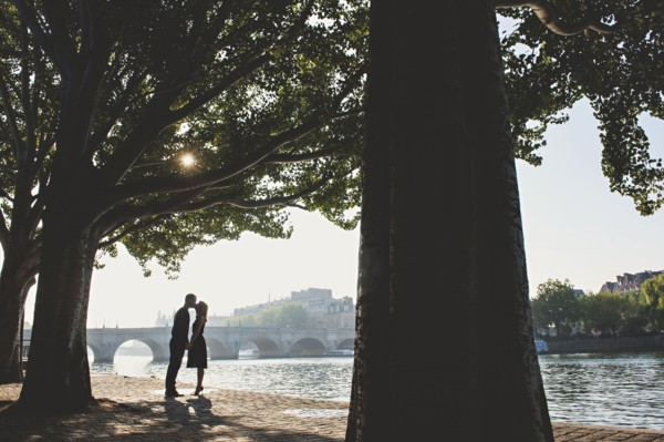 Caucasian couple kissing near bridge