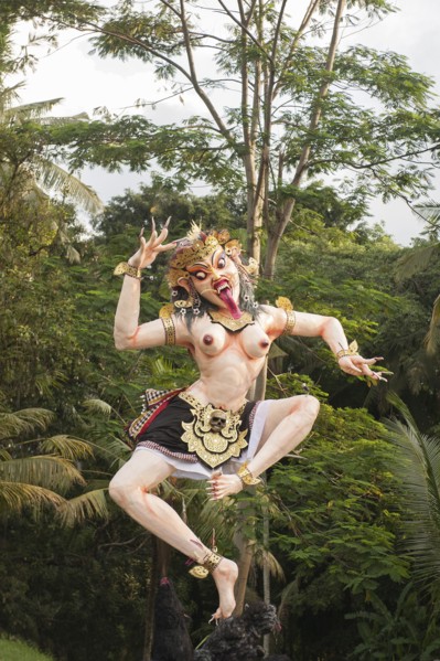 Statue of dancing deity in lush forest