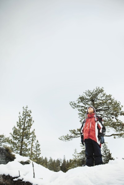 Boy standing in snow and looking up