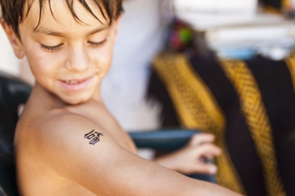Mixed race boy looking at temporary tattoo