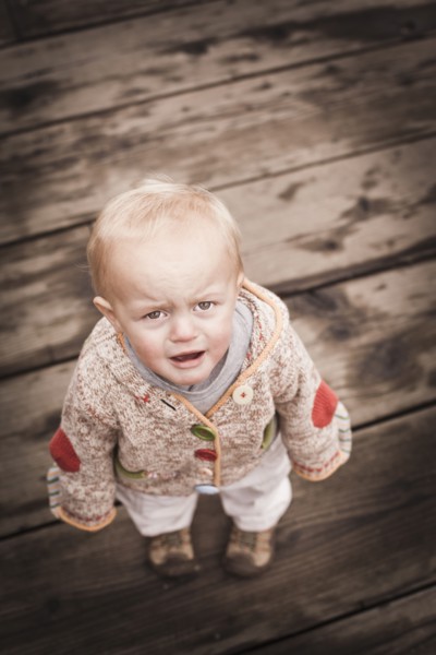 Frowning Caucasian boy standing outdoors