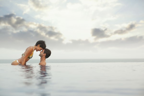 Hispanic couple enjoying swimming pool