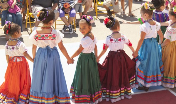 Hispanic girls dancing in costumes