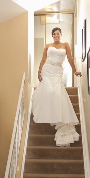 Hispanic bride standing on staircase