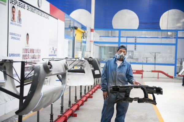 Worker holding machinery in manufacturing plant