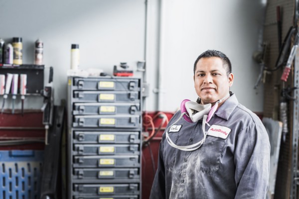 Hispanic mechanic standing in auto shop