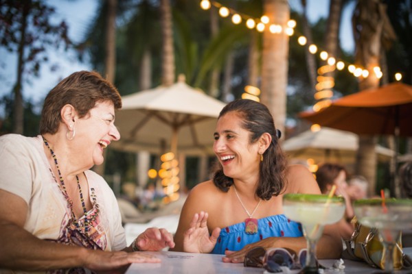 Mother and daughter laughing at outdoor table