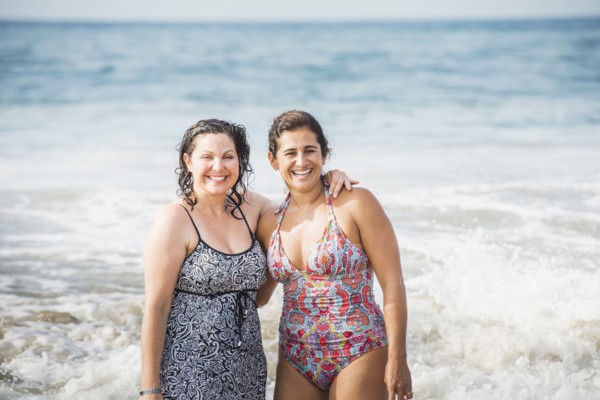 Women smiling together in ocean waves